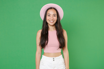 Fototapeta premium Smiling pretty young asian woman girl in casual pink clothes hat posing isolated on green background studio portrait. People sincere emotions lifestyle concept. Mock up copy space. Looking camera.