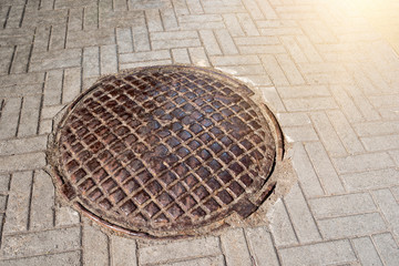 Iron manhole on the sidewalk. Housing and communications.