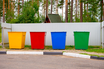 Green, yellow, red, blue color street trash cans on the street. Containers Selective collection of waste. Environmental pollution concept.