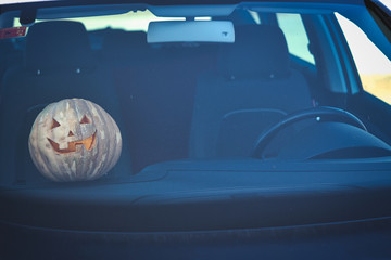 Halloween pumpkin inside a car.