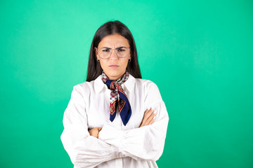 Young beautiful business woman over isolated green background skeptic and nervous, disapproving...