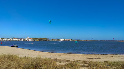 People practicing kitesurf. Kitesurfers on the mouth of the Cavado River in Esposende, Portugal. Esposende it's renowned by kite-surfers as one of the best places to kitesurf.