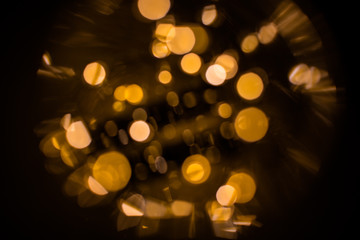 Golden bright glow bokeh. Christmas vintage lights on black background. Colorful blurred abstract defocused