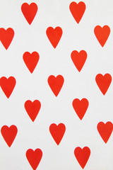 Top view of red hearts on the white surface. Location vertical.