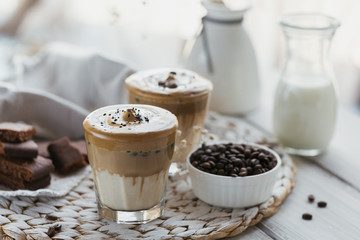 Dalgona whipped coffee, instant, cream, iced coffee. Cocktail with coffee, milk and ice cubes on light background mockup. Trendy drink background with copy space for text.
