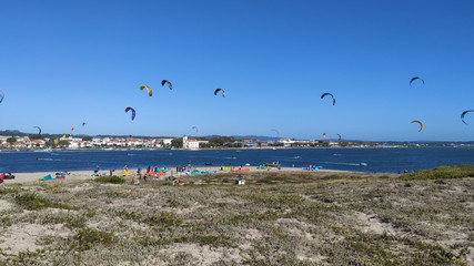 People practicing kitesurf. Kitesurfers on the mouth of the Cavado River in Esposende, Portugal. Esposende it's renowned by kite-surfers as one of the best places to kitesurf.