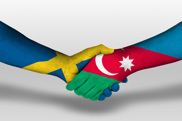 Handshake between azerbaijan and sweden flags painted on hands, illustration with clipping path.