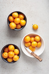 Ripe yellow mirabelle plums in bowls.