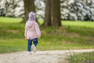 Yound kid hanging around in a park in spring