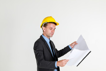 portrait of  a caucasian architectual Engineer wearing hardhat looking at the construction layout drawing on white background copy space