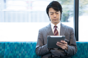 電車でタブレットPCを見るビジネスマン © Paylessimages