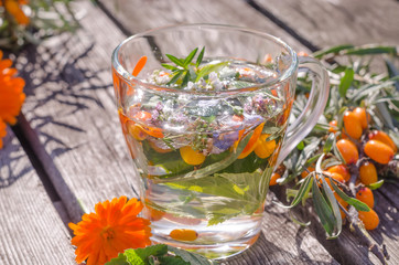 Herbal tea with lemon balm and sea buckthorn in the sun.