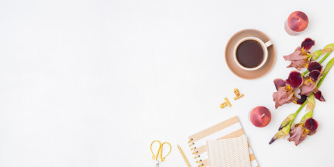 Flat lay composition with a cup of coffee and irises flowers on a white background