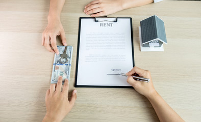 Fototapeta na wymiar Buyer hand signs contract after Real estate agents explains a business contract, lease, purchase, mortgage, loan, or home insurance