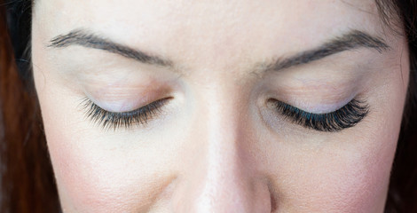 Close-up of female eyes with extended eyelashes. Before and after.
