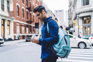 Ethnic male using smartphone on street