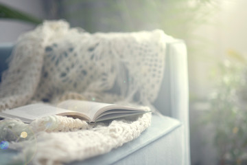cozy living room with a turquoise sofa. book is lying on a sofa, the concept of a literary circle