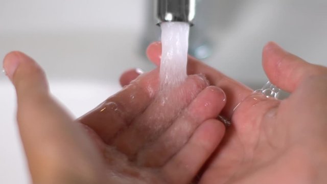 Slow motion of woman the hands after washing in the sink of the bathroom during Covid-19 pandemic to disinfect and eliminate germs and viruses. Hygiene, personale care, safe.
