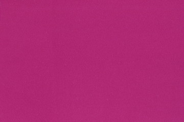 The texture of the fuchsia knit fabric. Beautiful background of bright pink natural cotton fabric.