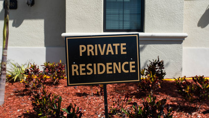Fototapeta na wymiar Sign stating 'PRIVATE RESIDENCE' on residential property in a golf community neighborhood, South Florida