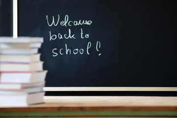 back to school concept pile of books and chalkboard