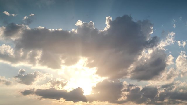 Timelapse footage of clouds with rays of sunlight in the sky