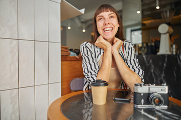 Beautiful laughing female photographer resting after working outdoor
