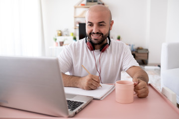 Obraz premium young man working remotely with leptop at his home. Distance Learning.