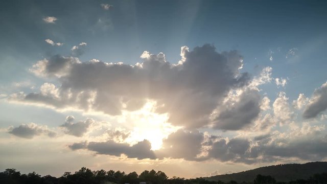 Timelapse footage of clouds with rays of sunlight in the sky