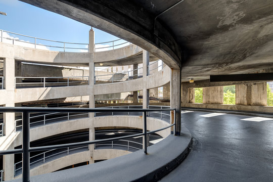 A spiral ramp in a concrete parking garage. - Powered by Adobe