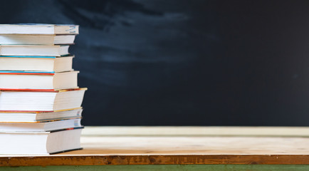 back to school concept pile of books and chalkboard