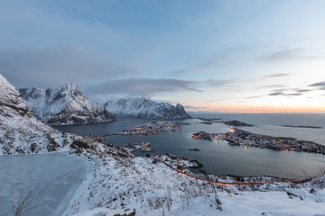 View from Reinebringen summit on Reinevatnet lake and Reine village and fjord during snowy winter. Lofoten, Norway