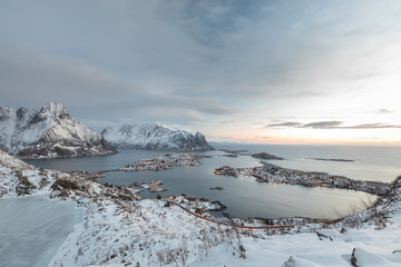 View from Reinebringen summit on Reinevatnet lake and Reine village and fjord during snowy winter. Lofoten, Norway