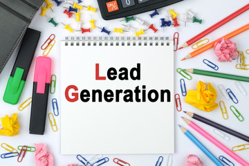 On the table is a calculator, diary, markers, pencils and a notebook with the inscription - Lead Generation