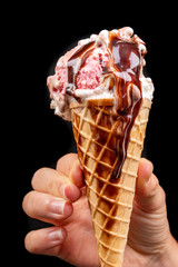 Tasty wafer ice cream in hand with chocolate glaze. Fruit dessert in a crispy wafer.