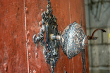 Obraz premium An Old Wrought Iron Antique Door handle on iron door.