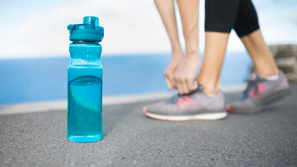 Female  runner with bottle of water, Drink and work out,  healthy diet concept. 