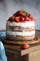 Chocolate and cream naked cake decorated with strawberries