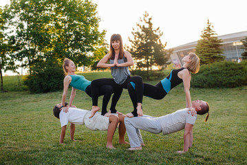 A group of people do yoga in the Park at sunset. Healthy lifestyle, meditation and Wellness