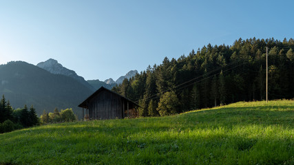 Fototapeta premium Wooden shed in a Swiss field and a view on Rocher Plat, Switzerland 