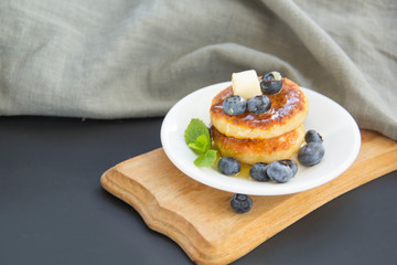 A healthy breakfast of pancakes, berries, butter, and honey