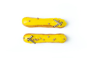 French glazed yellow eclairs with lemon cream, sweet dessert on white, top view