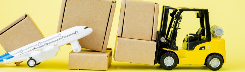 Mini forklift truck load cardboard boxes in the Airplane. Fast delivery of goods and products. Logistics, connection to hard-to-reach places. Banner, copy space