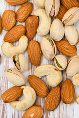 Different varieties of nuts on a wooden background.