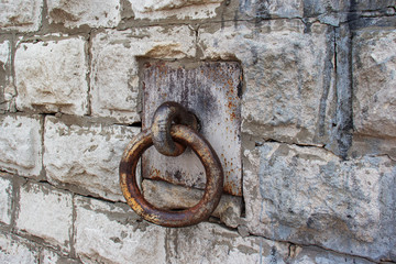Old iron ring in a metal loop on a stone wall