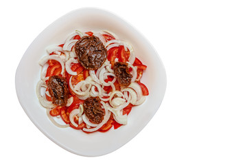 tomato salad with onions and sun-dried tomatoes in a bowl isolated on white, vegan food