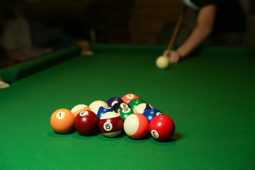 backdrop of pyramid of pool balls on green billiard table