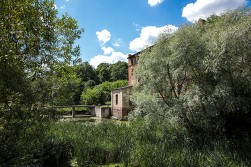 Obraz premium An old watermill on the river in summer.