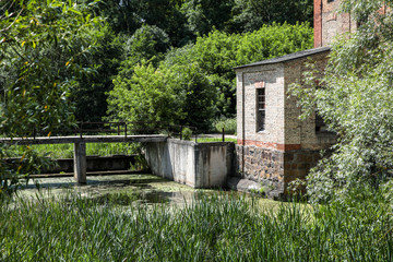 Fototapeta na wymiar An old watermill on the river in summer.