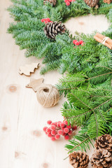 Christmas wreath on wooden table, with pinecones, decorative berries, fir tree branches, selective focus on berries